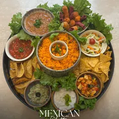 Our Mexican Platter is a fiesta of flavors. It features spicy rice, nachos with salsa and guacamole, bean dip, and other zesty bites, all arranged on a bed of fresh lettuce for a vibrant presentation.