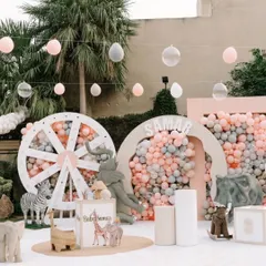 The main decor setup for the pastel jungle party, with a custom name sign, a giant wheel backdrop, and an array of cute animal figures.