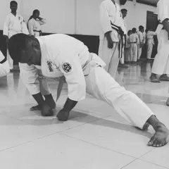 A little progress each day adds up to big results. This image shows a student building strength and conditioning their body through challenging knuckle push-ups.