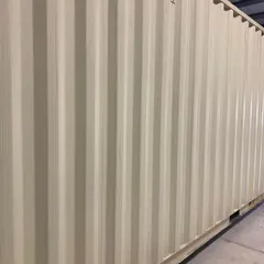 A close-up of the corrugated steel siding of a new high-cube container. This material is not only incredibly strong but also provides a unique architectural texture for modern and industrial designs.