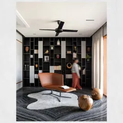A dedicated library in the Kamala Residence, featuring dramatic black marble flooring and a full-wall bookshelf. This space was designed to be a quiet, inviting retreat for the client, who is a passionate reader.