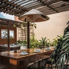 A daytime view of the outdoor kitchen, showing its proximity to the spa and jacuzzi area. This layout allows for effortless entertaining, where cooking, socializing, and relaxing can all happen together.