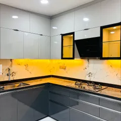 A look at a modern L-shaped kitchen I designed, featuring high-gloss grey and white cabinets for a sleek look. The design includes a marble-patterned backsplash and warm under-cabinet lighting, making the space both functional for cooking and aesthetically pleasing.