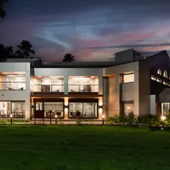 This is the result of our transformation project for the JNPT guesthouse. The architectural design features clean lines, expansive glass, and strategic lighting to create a striking and welcoming presence, especially at twilight.