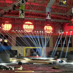The main stage of an e-sports event under construction, with spotlights being tested. We provide the blank canvas and technical support for elaborate and custom stage designs.
