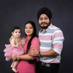A stunning family portrait against a dark grey background. The daughter's sparkling dress and the family's loving embrace make this a standout photo.