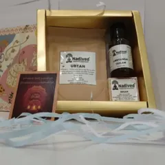 Another view of the Abhyanga Snan gift set, highlighting the natural products and the traditional greeting card included within the elegant gold box.