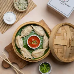 Another look at our classic steamed momos, arranged neatly in a circle. Each dumpling is carefully folded to hold in the juicy filling.