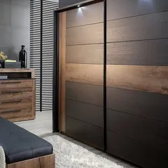 A modern sliding door wardrobe with a dual-tone wood finish, offering a space-saving solution for contemporary bedrooms.