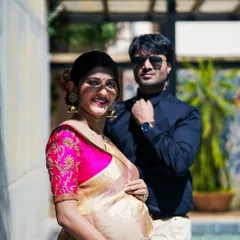 A beautiful outdoor maternity portrait of the couple. The mother-to-be is glowing, and her partner stands supportively behind her, creating a lovely composition.