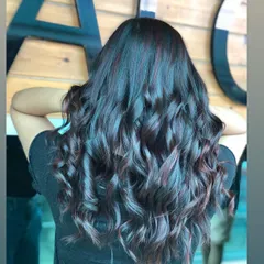 This is a gorgeous example of deep violet highlights woven into dark, wavy hair. The color adds a touch of mystery and sophistication, creating a look that is both bold and elegant.