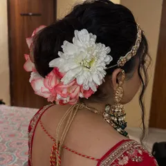 A side view of a floral bun, showing how the flowers are placed to complement the bride's jewelry and outfit.