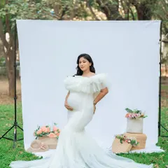 Using a simple white backdrop outdoors gives us the best of both worlds: the clean look of a studio and the beautiful, soft light of nature. This mom-to-be looks absolutely radiant in her elegant white maternity gown.