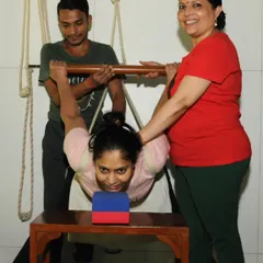 This is a therapeutic backbend using a stool, ropes, and assistance. The props provide complete support, allowing the student's spine to open passively and safely, targeting deep-seated stiffness that is otherwise inaccessible.