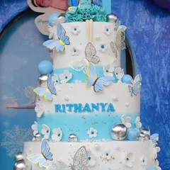 An impressive 8kg, three-tiered cake in a blue ombre design, adorned with dozens of delicate blue and silver butterflies.
