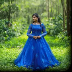 A true princess gown. This royal blue ball gown features intricate lace and beadwork on the bodice and a full, flowing skirt, perfect for a magical photoshoot in the woods.