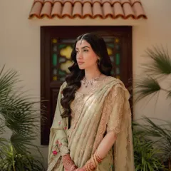A portrait of the bride-to-be, exuding grace and elegance. The soft, natural light highlights her intricate attire and thoughtful expression, capturing a moment of quiet anticipation before the celebrations begin.