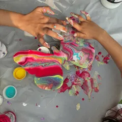 The pure joy of messy hands. This is from a kids' art stall where they got to try fluid art, pouring and mixing colors to their heart's content.
