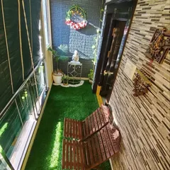 Even a very narrow balcony has great potential. I maximized this space with wall-to-wall artificial grass, a foldable wooden bench for seating, and a mix of wall decor and small plants to create a charming and usable green corner.