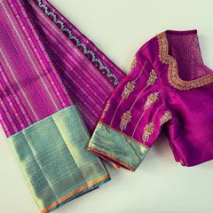 A beautiful pairing of a magenta silk saree with a custom blouse. The sleeve embroidery incorporates motifs and colors from the saree's border.