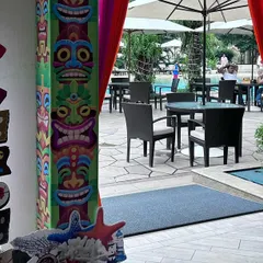 The entrance to a Hawaiian-themed pool party. We used colorful tiki-style pillars and a rustic wooden signpost to guide guests to the celebration.