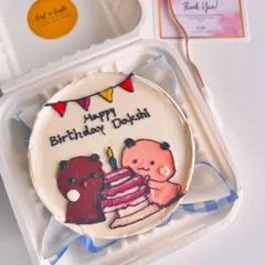 A personalized birthday bento for Dakshi, showing two cute bears celebrating with a layered birthday cake and candle.