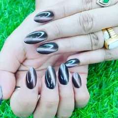 A close up of this stunning cat-eye nail art in a deep, glossy brown. The magnetic effect creates a beautiful light-reflecting band across the nail, giving it a unique, gem-like quality. I shape each nail extension carefully to achieve this perfect oval look.