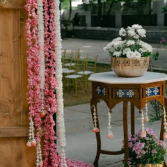 A close-up of the floral decor on the entrance arch, featuring cascading garlands of pink and white flowers.