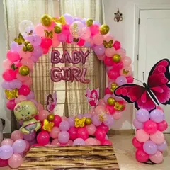 A beautiful butterfly-themed welcome decoration for a baby girl. This design features a full circular balloon arch in shades of pink and gold, accented with butterfly cutouts for a whimsical touch.