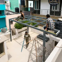 Precision is key. Our fabricators are seen here taking exact measurements on the installed frame, ensuring that every component aligns perfectly before the glass panels are mounted. This attention to detail guarantees a flawless fit and finish.