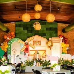 A wide view of this incredible indoor barnyard party for twins Sanmay and Smayan. The design transformed the space with a huge barn backdrop, rustic lighting, and themed table settings.