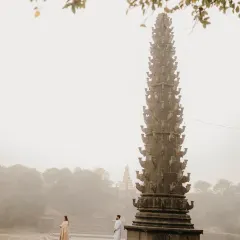 Standing by a 'deepstambh' in the morning mist. This atmospheric shot captures a sense of peace and devotion, reflecting a love that is deep and spiritual.