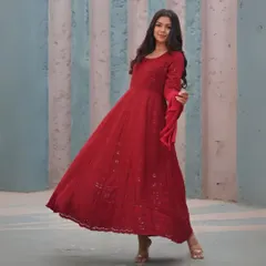 A floor-length red Anarkali suit with delicate embroidery. This is a timeless, elegant design that is perfect for celebrations and can be custom-made to your measurements.