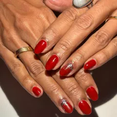 Timeless and bold. A classic red manicure with a touch of silver glitter on the accent nail is a go-to for any celebration.