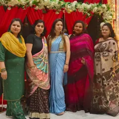 A group of friends and family at an event, with one of our clients looking lovely in a light blue ready-to-wear saree with an embellished belt.