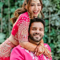 Pure happiness captured in a candid moment, with the bride hugging the groom from behind during their vibrant Mehendi function.
