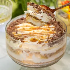A perfect bite of my Banoffee dessert. You can see the layers of biscuit, fresh banana, homemade caramel, and airy cream, all topped with chocolate shavings.