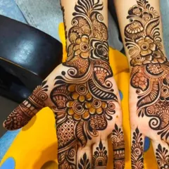 A beautiful example of a full-hand Arabic floral design. The pattern flows diagonally across the hand, combining large flowers with delicate vines and leaves for a very graceful effect.