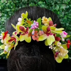 A colorful hair veni with a mix of green, pink, and yellow flowers. This is a wonderful choice for a spring wedding or a vibrant mehendi look.