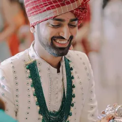 A happy, candid portrait of the groom during a wedding ritual. His genuine smile is the focus of this shot.
