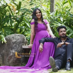 Our purple off-the-shoulder gown offers a simple, elegant look for a couple's maternity shoot. The flowing fabric and long train create a soft and romantic feel, perfect for relaxed outdoor photos.
