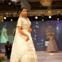 A model on the runway wearing one of my Kundan sets with a beautiful white lehenga. This shows how versatile my pieces are for high-fashion looks.