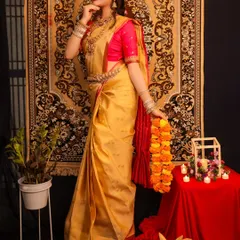 A full-length portrait from a concept shoot, showcasing a beautiful golden saree. The traditional props and setting help to create a festive and culturally rich atmosphere.