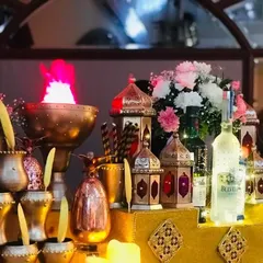 A close-up of the rich textures and warm lighting of the Sufi theme. Brass goblets, glowing lanterns, and a dramatic flame effect create a captivating and opulent bar front.
