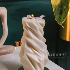 An elegant, twisted pillar candle in a soft ivory wax. Its modern, sculptural form adds a touch of sophistication to any minimalist or contemporary decor.