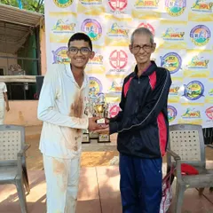 A young, determined player from our U-17 team receiving the MPL winner's trophy. The mud on his whites tells the story of a hard-fought final.