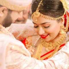 A close-up shot filled with emotion. The bride's joyful smile and bright red lipstick are the focus, capturing a moment of pure happiness during the wedding rituals.