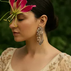 She’s not waiting for the light, she is the light. A model looking serene while wearing our elegant pearl and crystal chandelier earrings, a perfect accessory for an evening look.