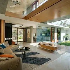 The living space of the Long House dissolves into the central courtyard through expansive glass walls. We designed this to create a seamless flow between the interior and the lush greenery, ensuring the home is filled with natural light and feels like an extension of the garden.