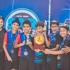 A young team proudly displays their medals and trophy. This is the reward for all their hard work and dedication.